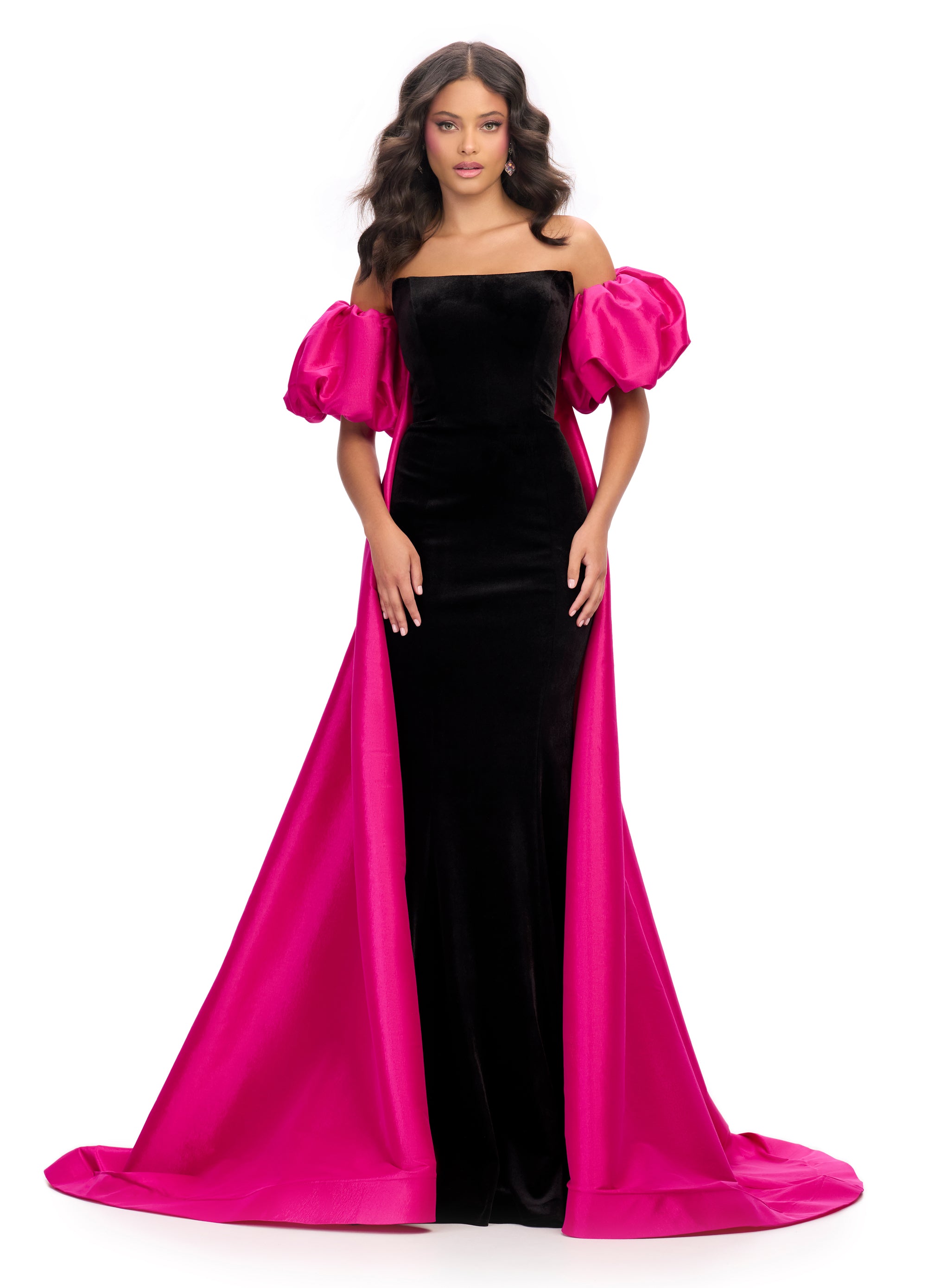 Elegant black strapless velvet gown with a fitted silhouette, bold blue off-shoulder puff sleeves, and a striking floor-length hot pink overskirt.
