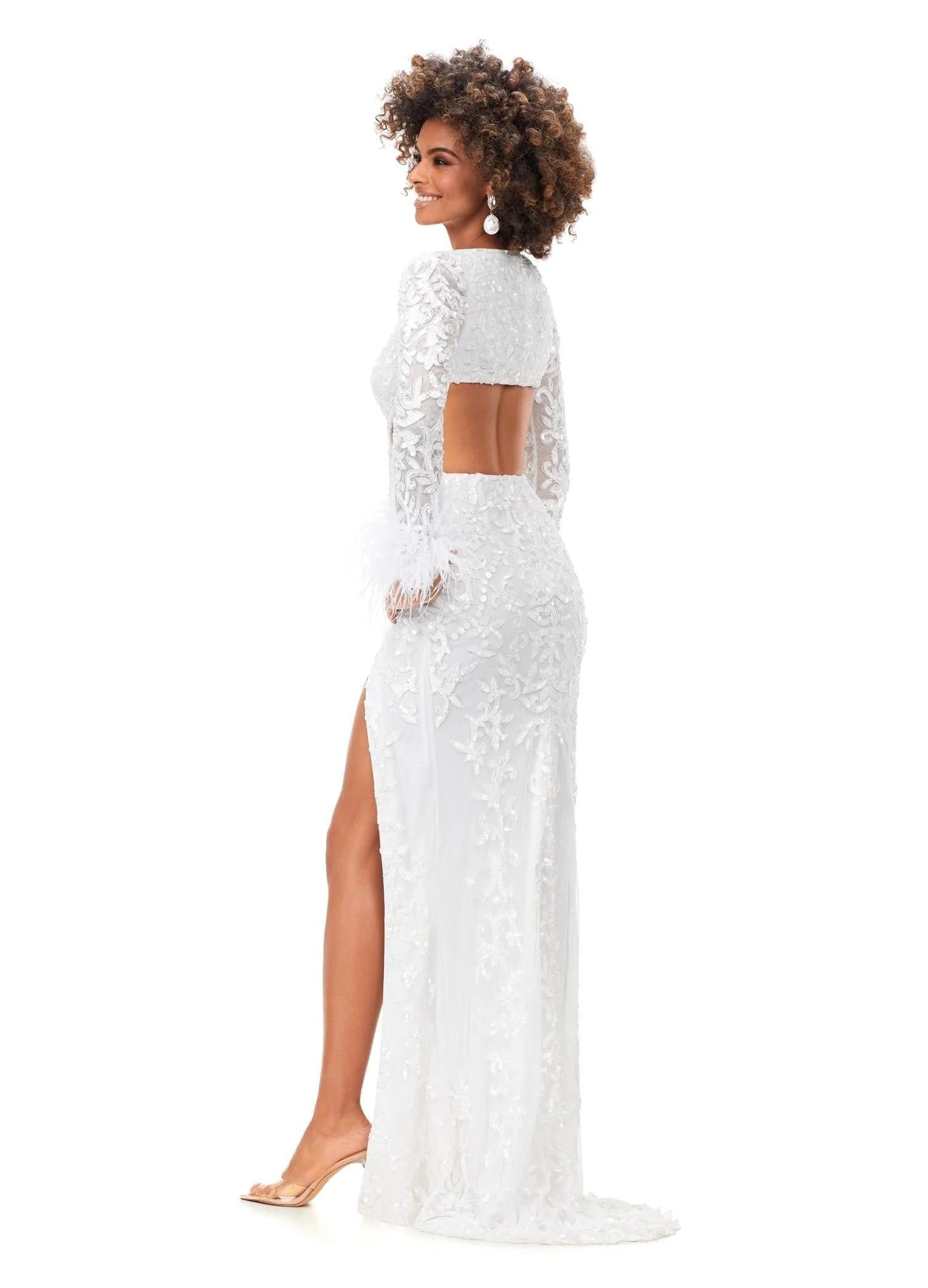 Back view - White gown featuring intricate embroidery, long sheer sleeves, feathered cuffs, a daring cutout waistline, and a high slit for a chic and elegant look.