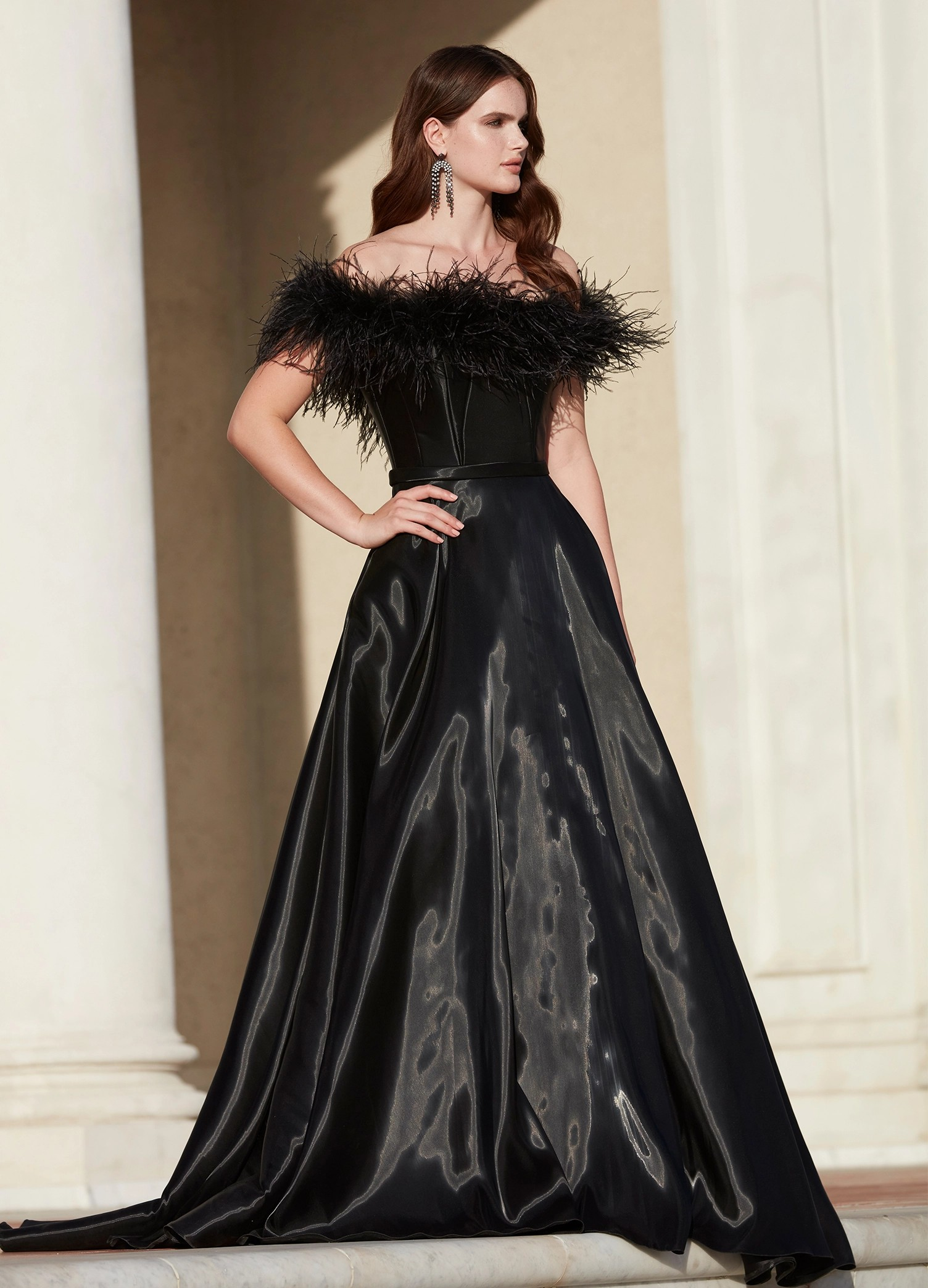 Elegant black ball gown featuring an off-the-shoulder feathered neckline and a flowing satin skirt for a timelessly dramatic look.