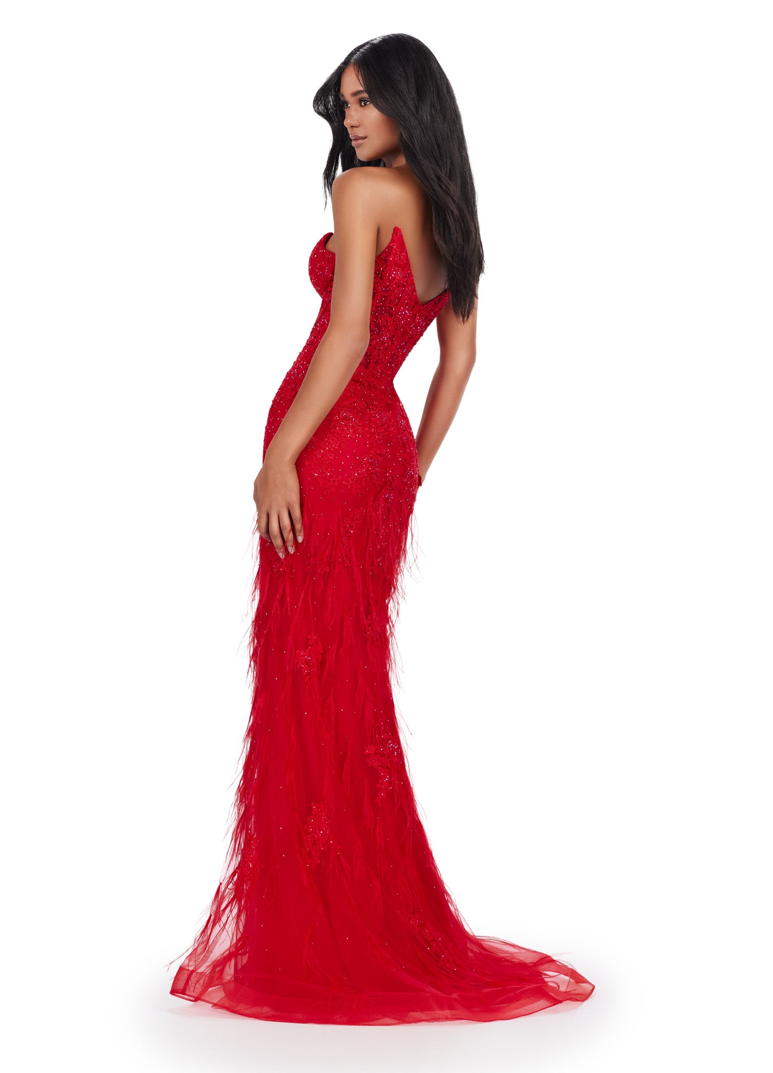 Elegant strapless red gown with a deep plunging neckline, featuring intricate beading and feather embellishments, flowing into a fitted silhouette and delicate tulle skirt.