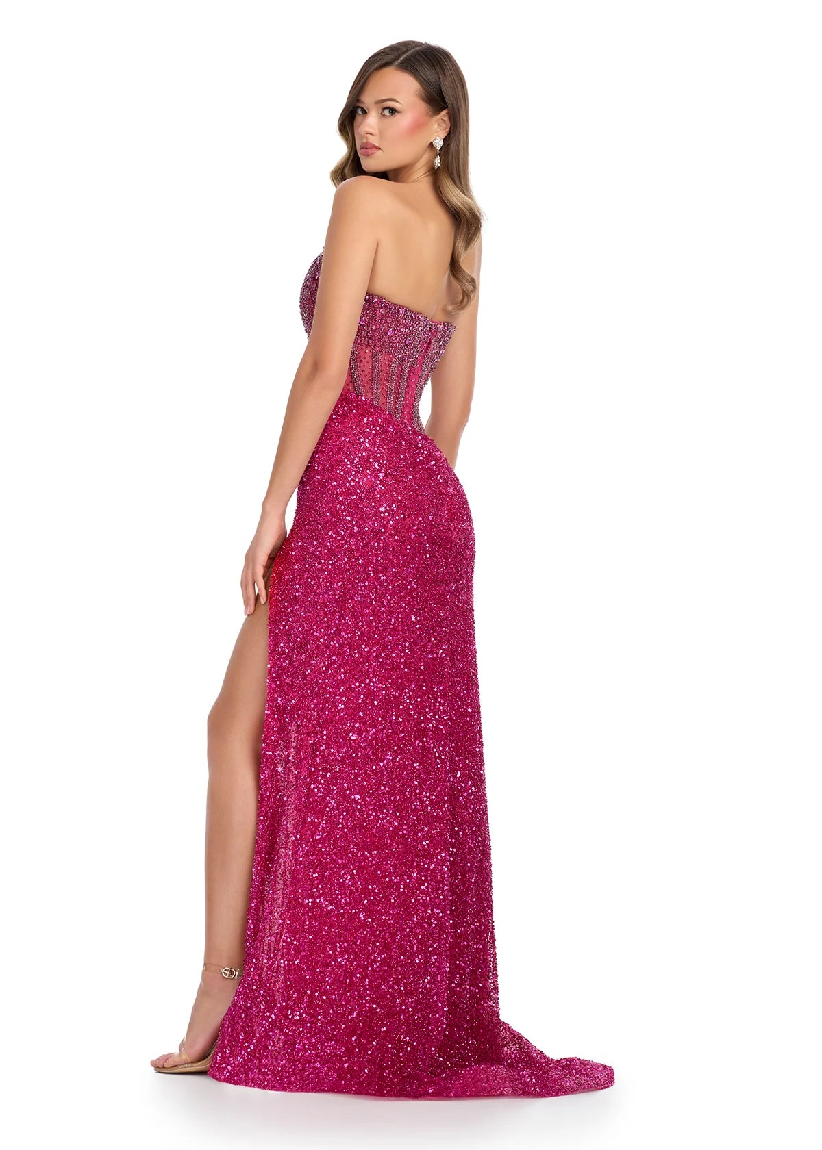 Back View - Fuchsia gown with a sheer embellished bodice, fitted sparkling skirt, high slit, and floor-length design.
