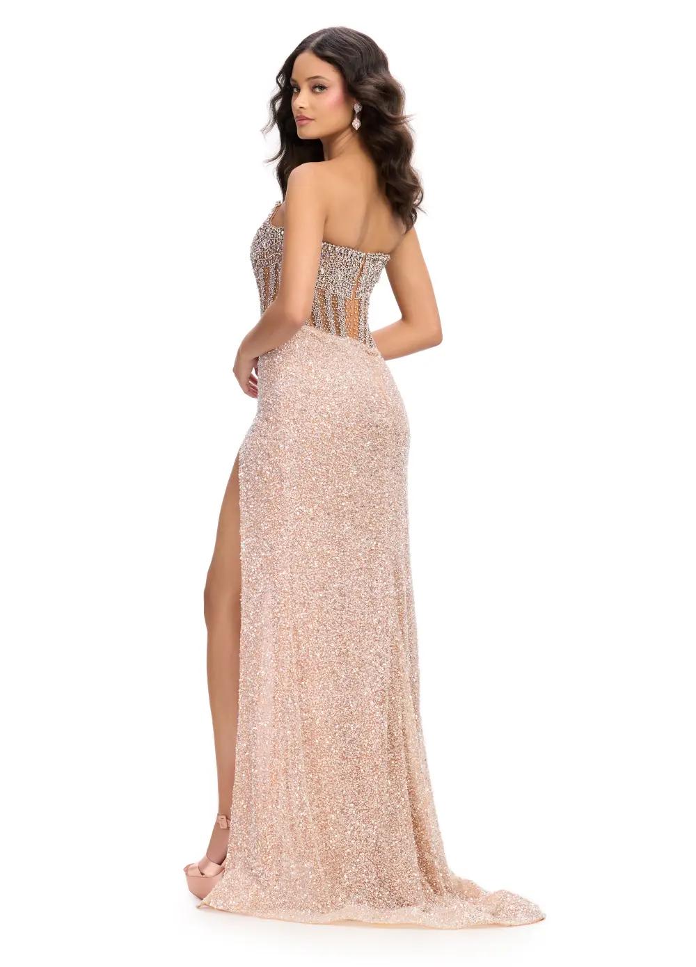 Back View - Nude gown with a sheer embellished bodice, fitted sparkling skirt, high slit, and floor-length design.