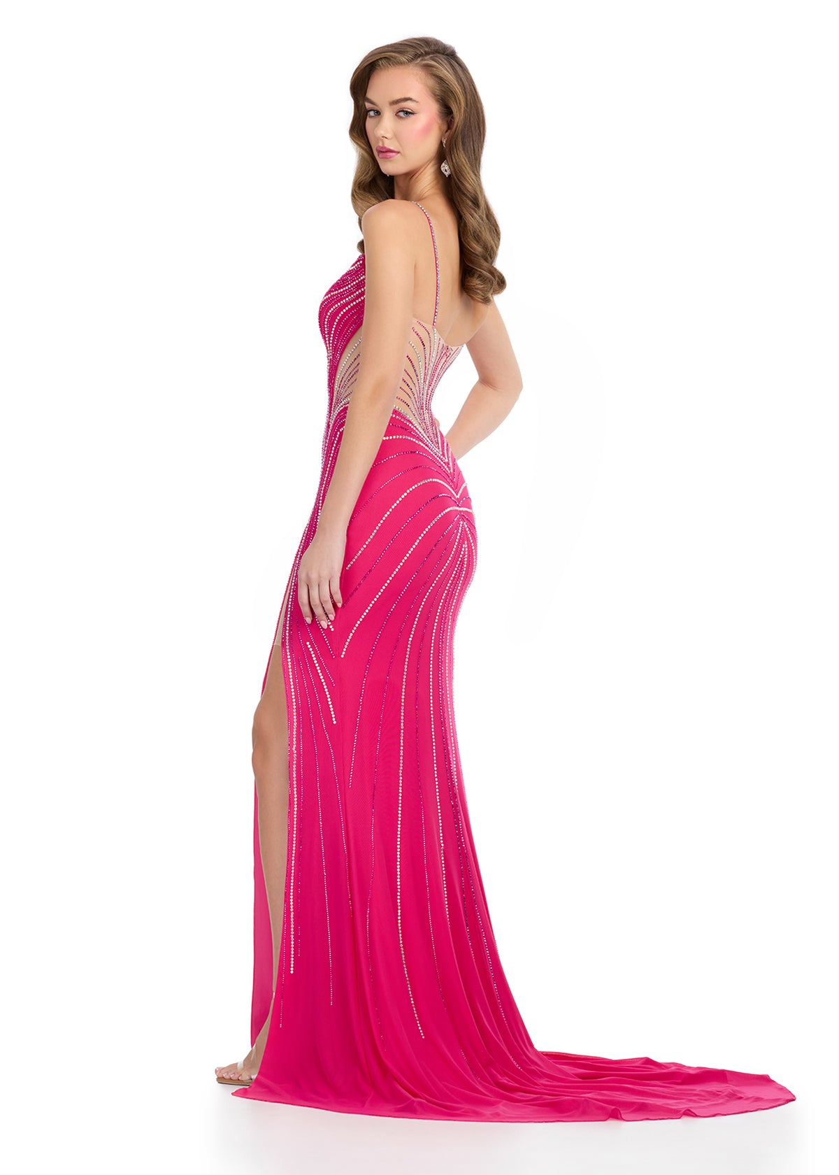 Back view of a stunning fuchsia pink evening gown with a sweetheart neckline, shimmering beadwork in wave patterns, a thigh-high slit, and sheer side panels.