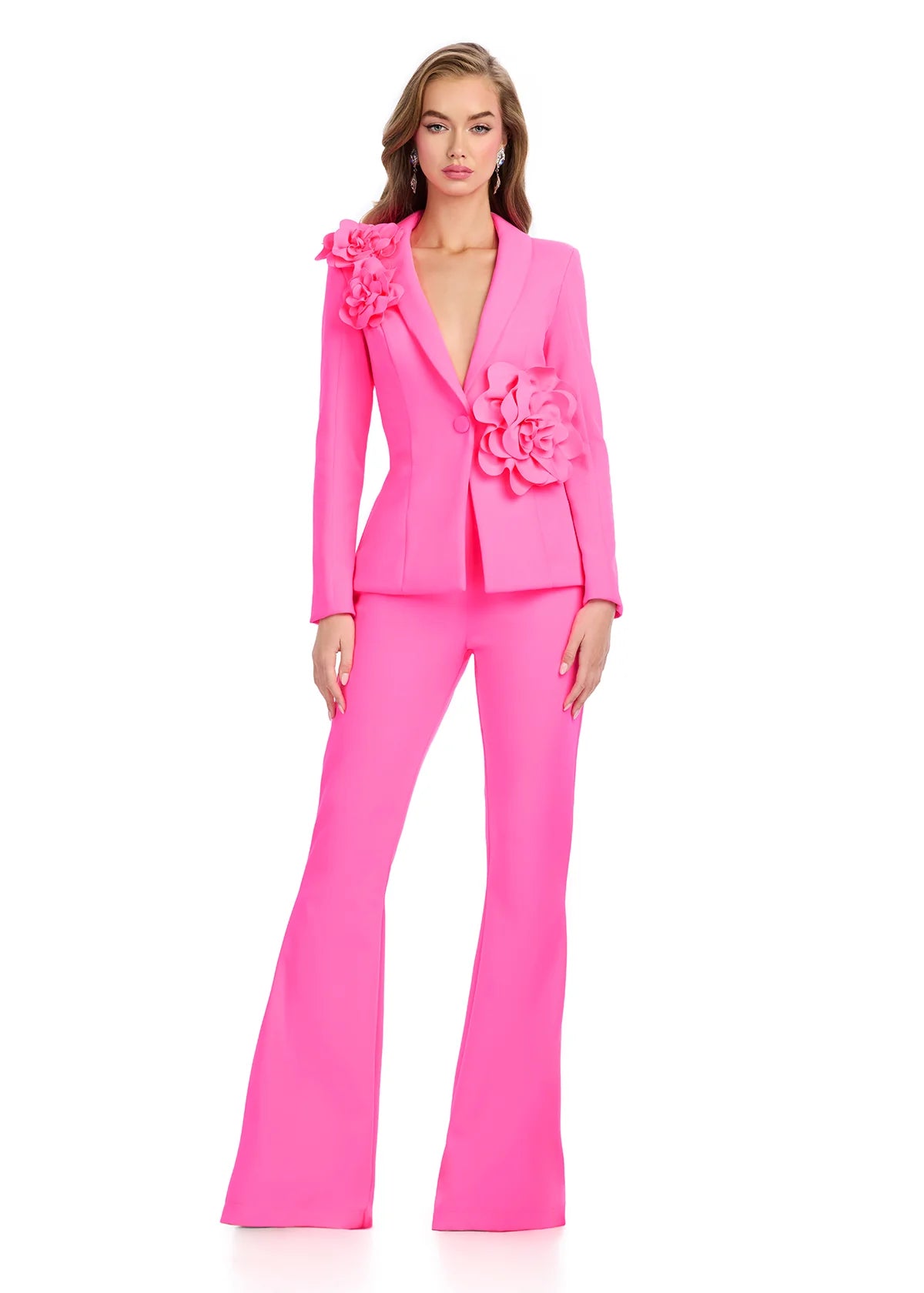 Bold pink tailored pantsuit with floral appliqué detailing on the blazer, offering a modern, feminine twist on classic formalwear.