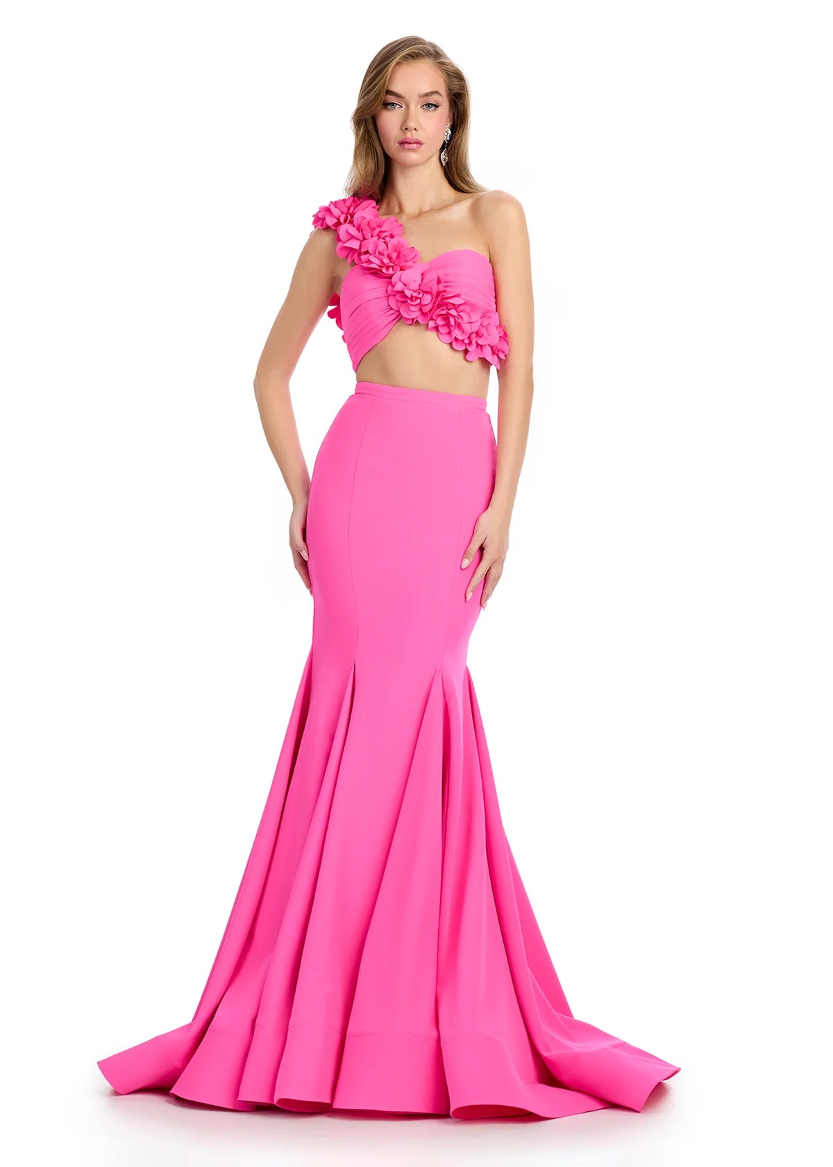 Hot pink two-piece gown featuring a strapless floral-embellished crop top and a fitted mermaid skirt with a dramatic flared hemline.