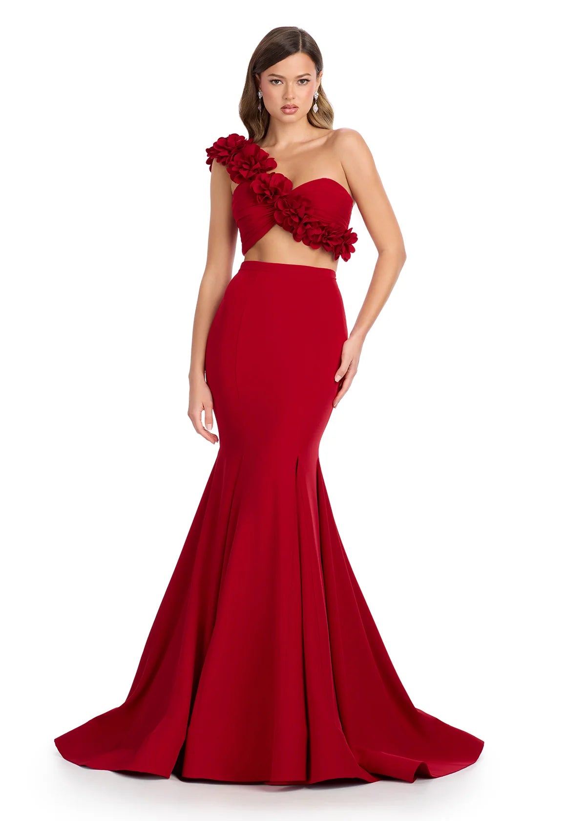 Red two-piece gown featuring a floral-embellished one shoulder crop top and a fitted mermaid skirt with a dramatic flared hemline.