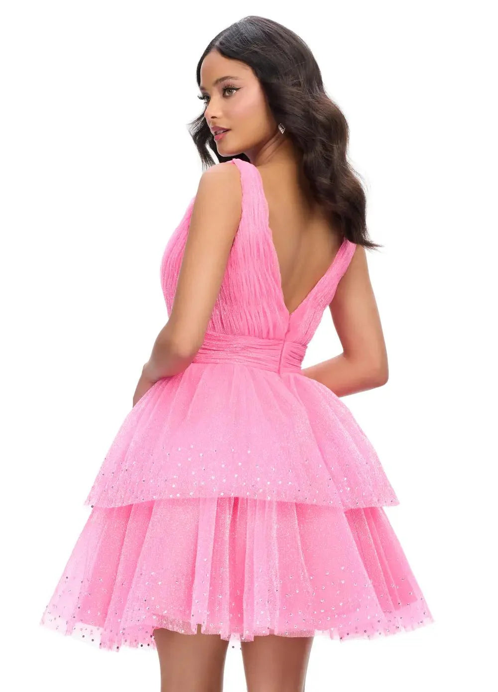 Pink tiered mini dress featuring a plunging V-neckline, delicate tulle layers with sparkling accents, and a cinched waist for a fairytale-inspired look. Back view.