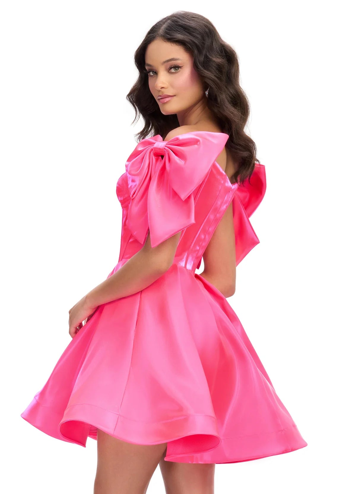 Back view of a striking pink mini dress with a structured corset bodice, voluminous skirt, and oversized bow accents on the shoulders, perfect for a bold and playful statement look.