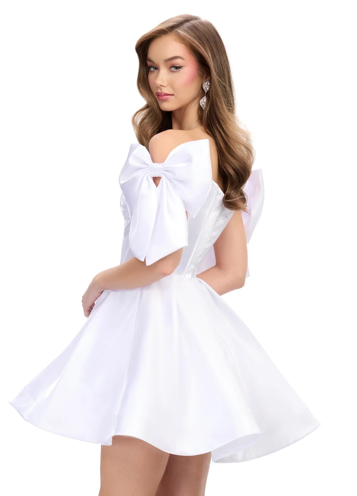 Side view of a striking white mini dress with a structured corset bodice, voluminous skirt, and oversized bow accents on the shoulders, perfect for a bold and playful statement look.