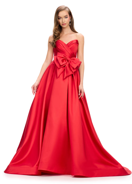 Emmelina | Red Strapless red ball gown featuring a pleated bodice, a statement oversized bow at the waist, and a dramatic full skirt with a floor-length design.