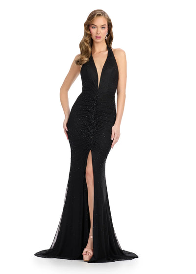 Video - Black halter-neck gown featuring a deep plunging neckline, ruched detailing, subtle embellishments, high slit, and a floor-length silhouette.