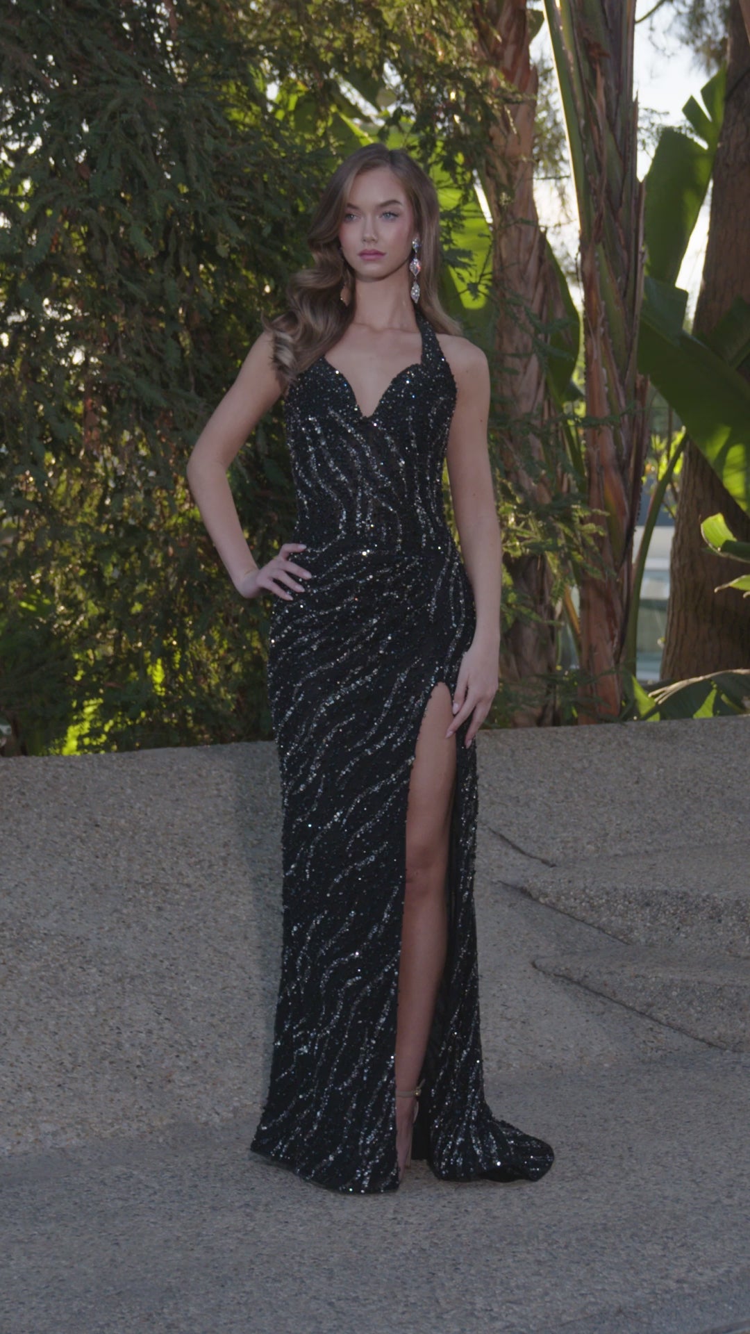 Video - Black beaded halter gown featuring a plunging neckline, high leg slit, and intricate swirling embellishments, perfect for creating a bold and glamorous statement.